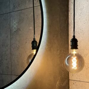 Modern bathroom design featuring a backlit mirror and filament light bulb.