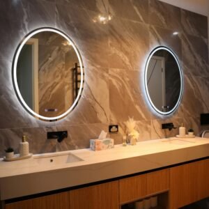Elegant bathroom interior featuring a double vanity with circular backlit mirrors, sleek design.